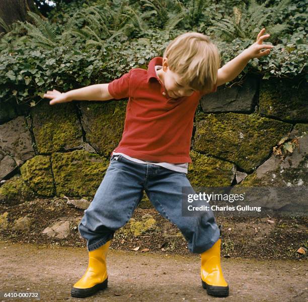 boy in rubber boots dancing - children dancing outside stockfoto's en -beelden