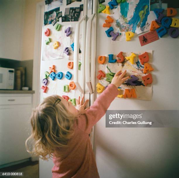 girl reaching letters - magnete foto e immagini stock