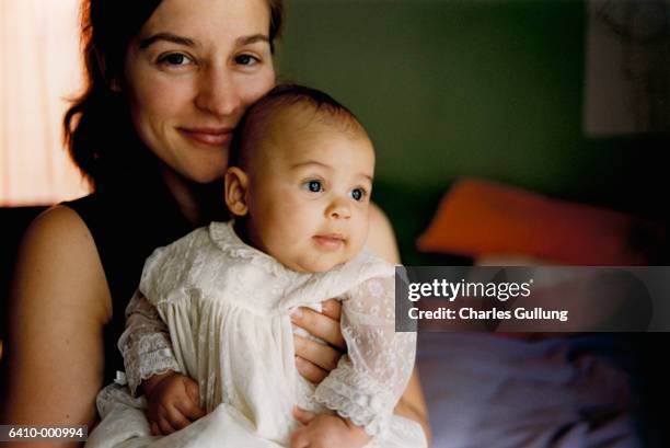mother holding baby - bautizo fotografías e imágenes de stock