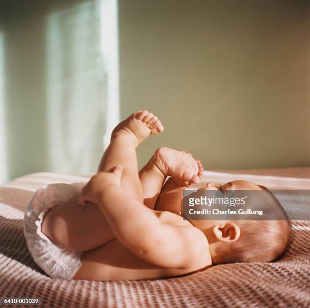 reclining baby - feet in bed stock-fotos und bilder
