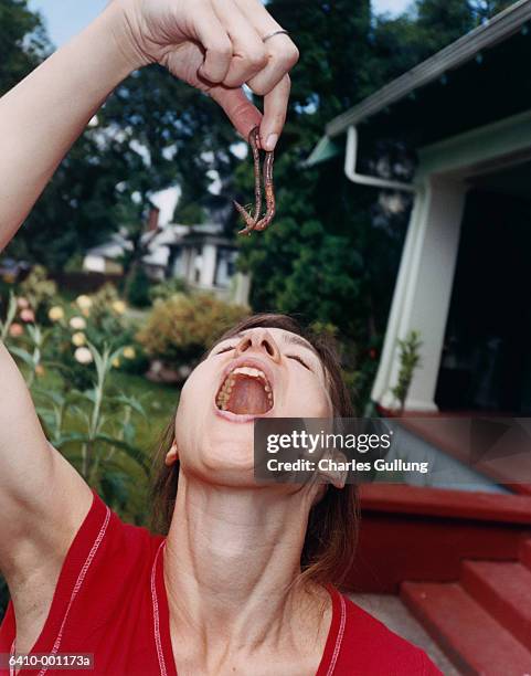 woman about to eat  earthworm - earthworm stock-fotos und bilder