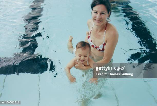 mother and baby in pool - babyschwimmen stock-fotos und bilder