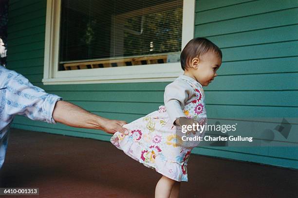 father holding toddlers dress - restraining photos et images de collection