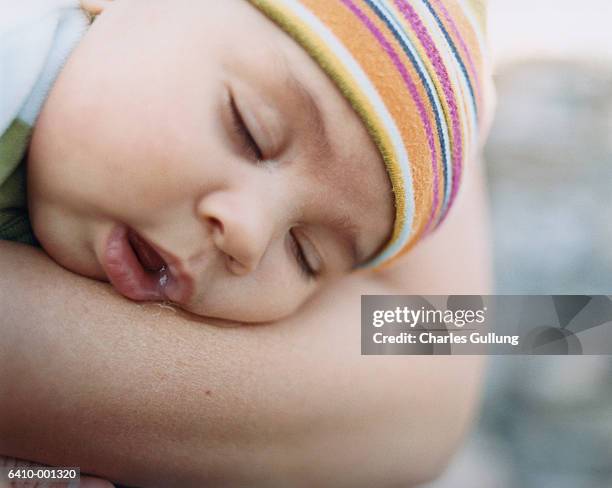 baby sleeping in persons arms - saliva stock pictures, royalty-free photos & images