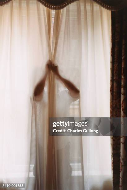 man hiding behind curtain - closing curtains stock pictures, royalty-free photos & images