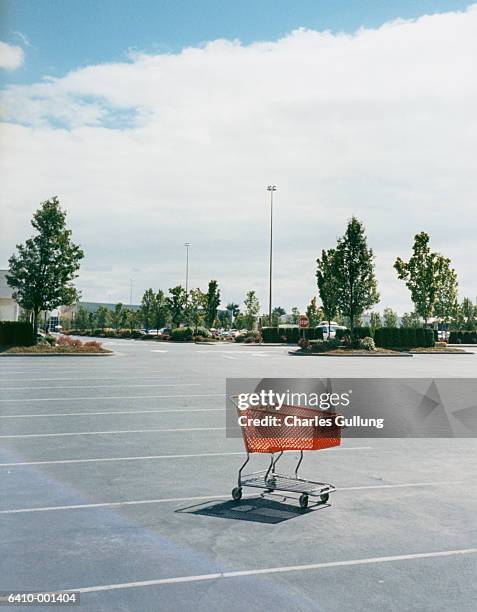 shopping cart in parking lot - empty parking lot stockfoto's en -beelden