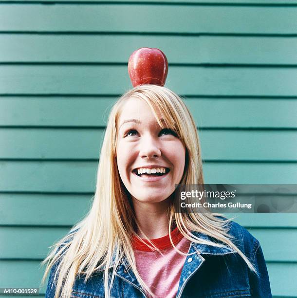 girl balancing apple on head - frau apfel stock-fotos und bilder