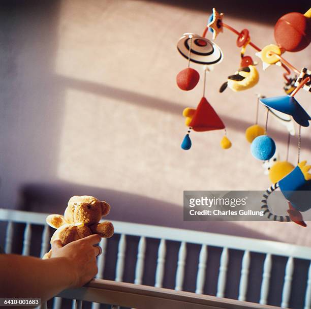 hand holding teddy bear - baby mobile stock pictures, royalty-free photos & images