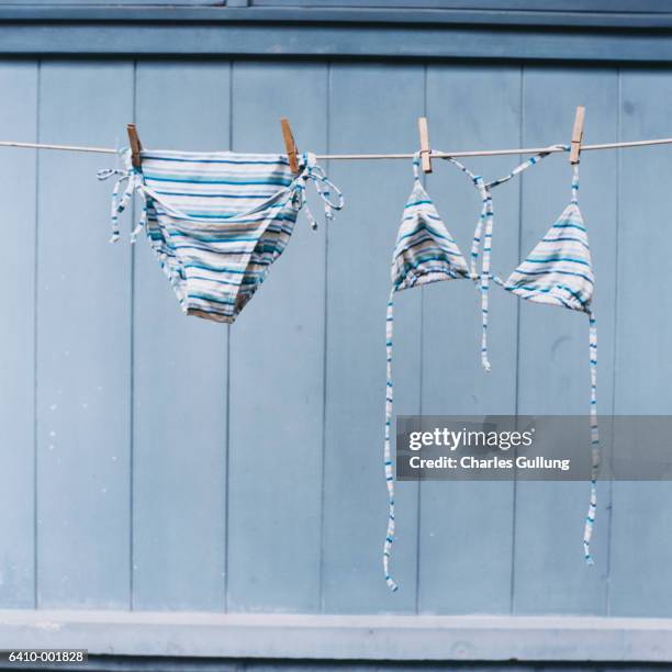 bikini hanging on clothesline - badebekleidung stock-fotos und bilder