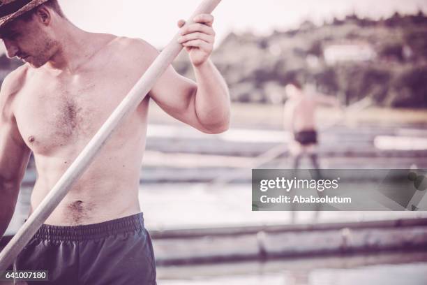 twee blanke mannen werken bij zoutpannen, secovlje, mediterrane, europa - minder verzadiging stockfoto's en -beelden