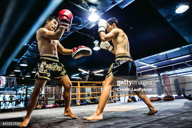 muay thai match on boxing ring in thailand - muaythai boxing stock pictures, royalty-free photos & images
