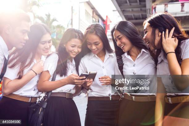 thai students in uniform in bangkok take a break together - thai people stock pictures, royalty-free photos & images