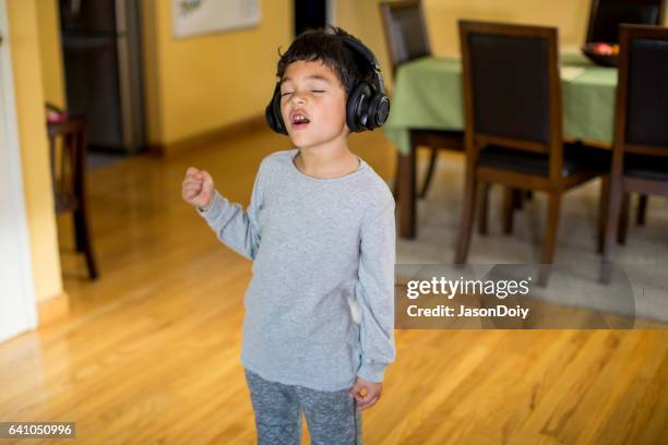 young boy listening to music and rocking out - boy singing stock pictures, royalty-free photos & images