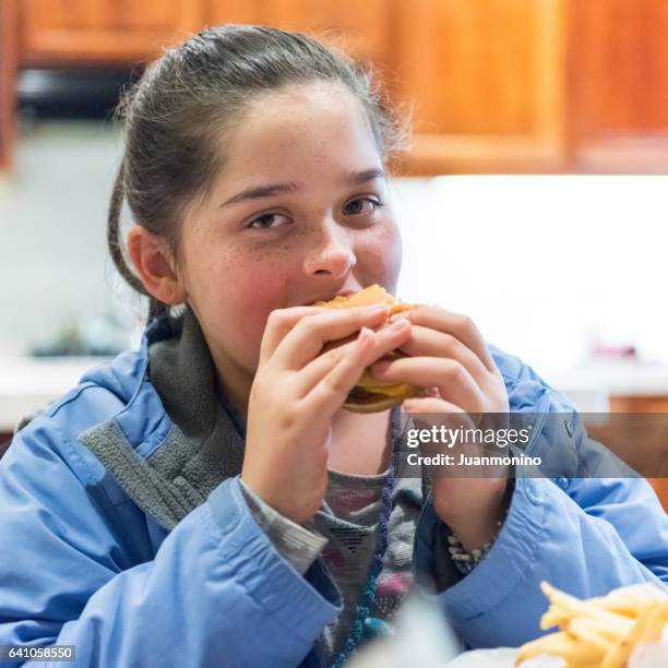 junge mädchen, das einen hamburger - fat girls stock-fotos und bilder