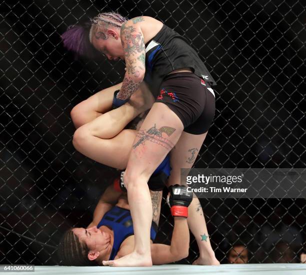 Tecia Torres battles Bec Rawlings on the cage in the Women's Strawweight Bout during UFC Fight Night at the Toyota Center on February 4, 2017 in...