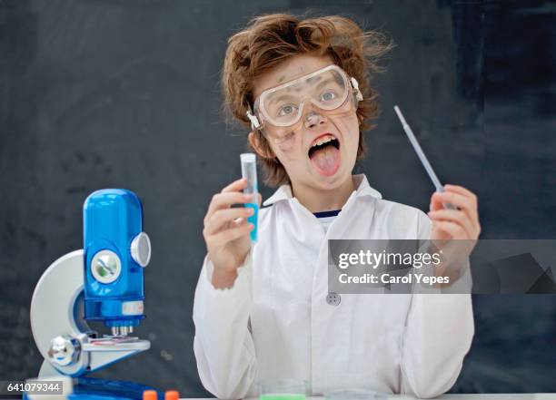 a blonde boy making some scientific experiments at class. - scientist and explosion stock-fotos und bilder