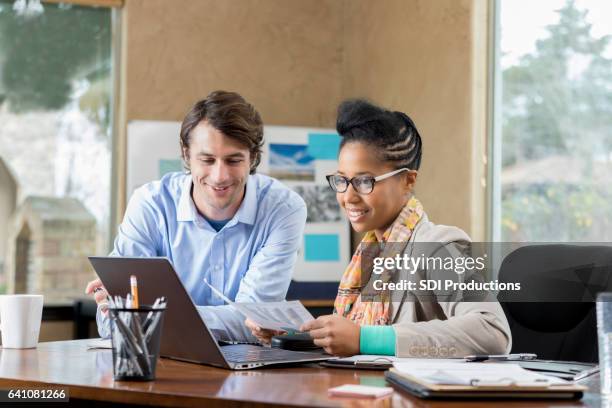 confident businesspeople review documents in the office - admin assistant stock pictures, royalty-free photos & images