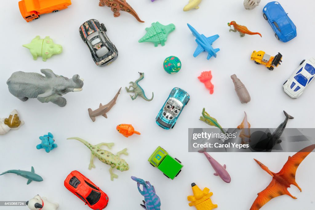 Collection of plastic and rubber toys on a white surface.Top view.