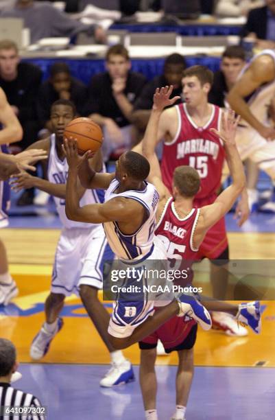 Duke University guard Chris Duhon makes a leaping shot around University of Maryland guard Steve Blake during the Division 1 semifinal game of the...