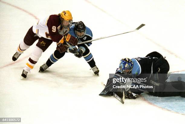 Johnny Pohl of Minnesota challanges Peter Metcalf and and Matt Yeats of the University of Maine during the Division 1 Men's Hockey Championship held...