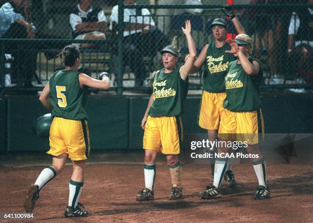 Freshman Jess Christensen of North Dakota State University is congratulated by her teammates after scoring in the first inning against Kennesaw State...