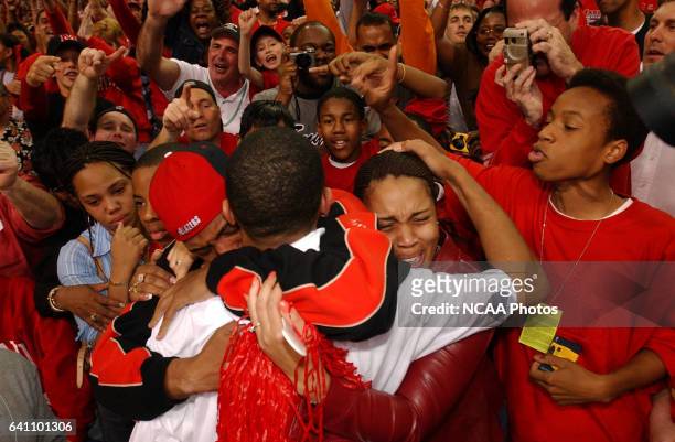 Juan Dixon of Maryland, center, celebrates and gets a hug from his brother Phil Dixon, left, and his sister Nicole Dixon, right, following the NCAA...