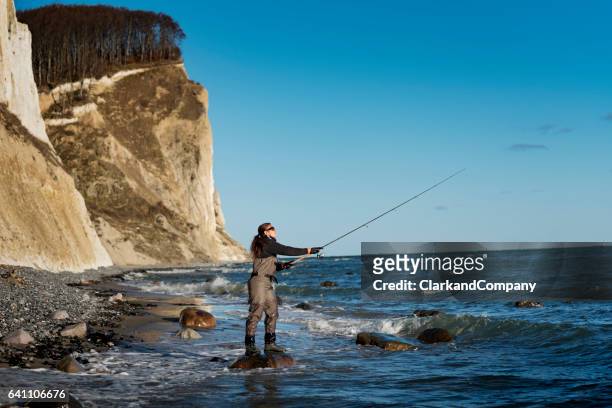 woman sea fishing at møns klint denmark - waders imagens e fotografias de stock