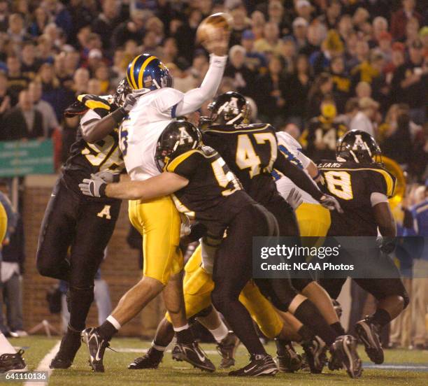 Defensive linemen Anthony Williams and Daniel Finnerty of Appalachian State sandwich quarterback Joe Flacco of the University of Delaware during the...