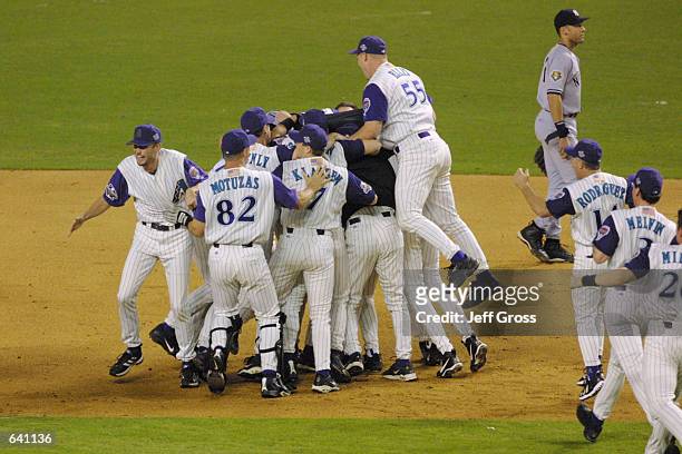 Members of the Arizona Diamondbacks celebrate defeating the New York Yankees to win game 7 to capture the World Series at Bank One Ballpark in...