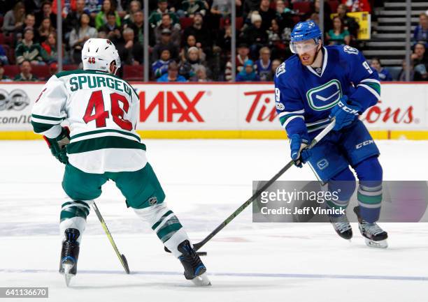 Jared Spurgeon of the Minnesota Wild looks on as Jack Skille of the Vancouver Canucks skates up ice with the puck during their NHL game at Rogers...