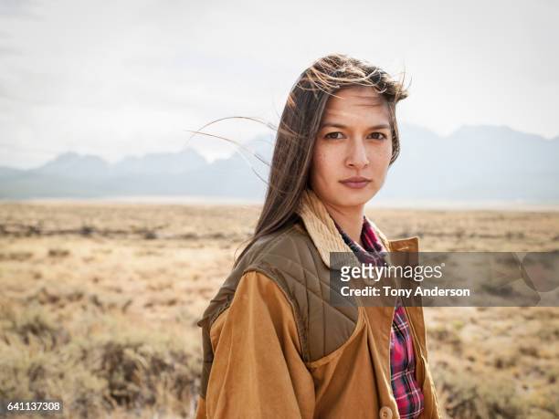 young woman in dramatic mountain landscape - aboriginal woman stock-fotos und bilder