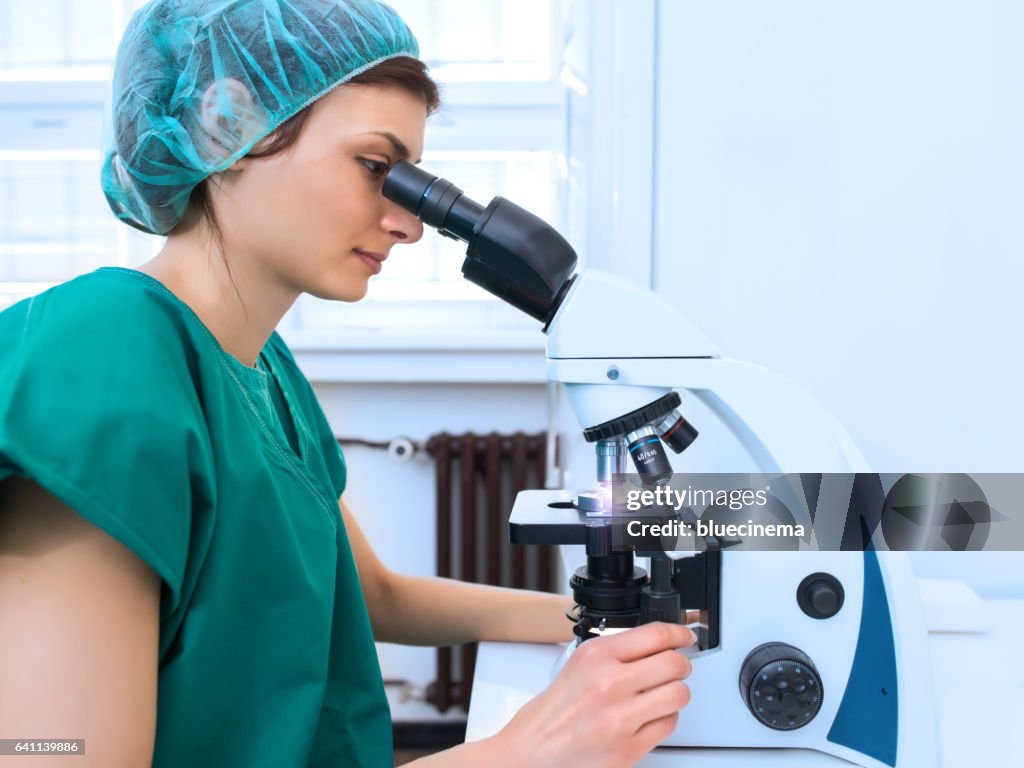 Female scientist looking through a microscope