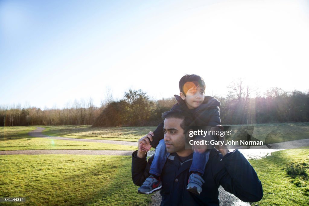 Dad carrying young son on shoulders