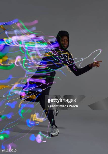 the dancer has led lights attached to him, while moving around fast he creates the burst of light - premiere of vertical entertainments in darkness arrivals stockfoto's en -beelden