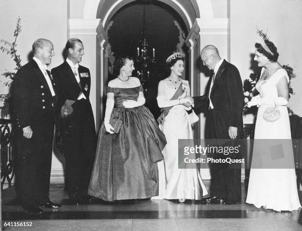 British monarch Queen Elizabeth shakes hands with US President Dwight D Eisenhower at the White House during a state visit, Washington DC, 1957. Also...