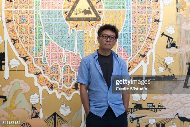 Artist Gonkar Gyatso poses in front of one of his works during the Pop Phraseology exhibition at the Pearl Lam Galleries in Hong Kong on 17 Sept 2014.