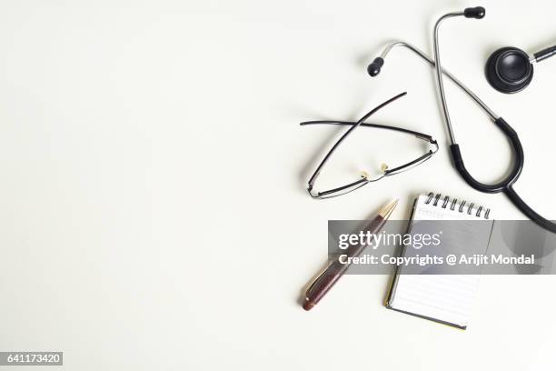 white modern doctor desk table with stethoscope and supplies copy space flat lay - doctor desk stock pictures, royalty-free photos & images