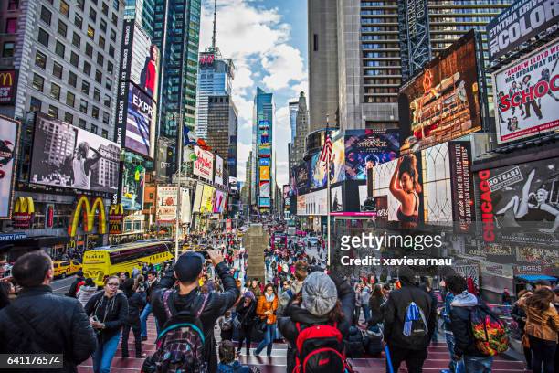 view of crowded times square in new york city - times square manhattan stock pictures, royalty-free photos & images