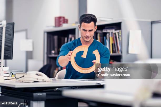 businessman examining model at desk in office - as g stock pictures, royalty-free photos & images