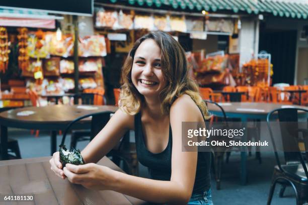 vrouw eten in chinatown district in singapore - singapore food stockfoto's en -beelden