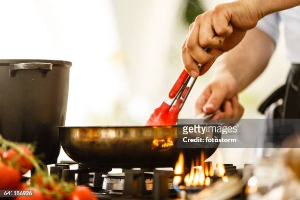 food in a frying pan being stirred with a spoon - stir frying european stock pictures, royalty-free photos & images