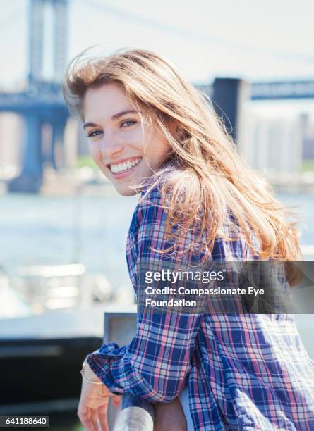 smiling woman by manhattan bridge, new york - plaid shirt stock pictures, royalty-free photos & images