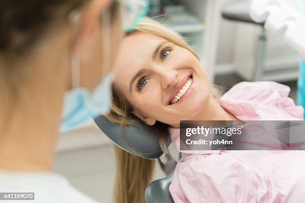 beautiful patient smiling at doctor - dentist's chair stock pictures, royalty-free photos & images