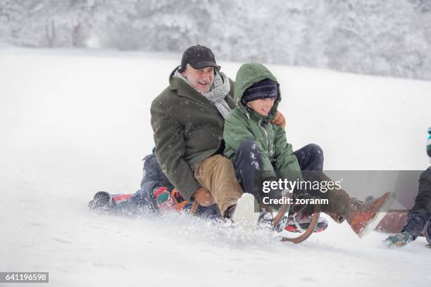 familie rodeln - grandfather child snow winter stock-fotos und bilder