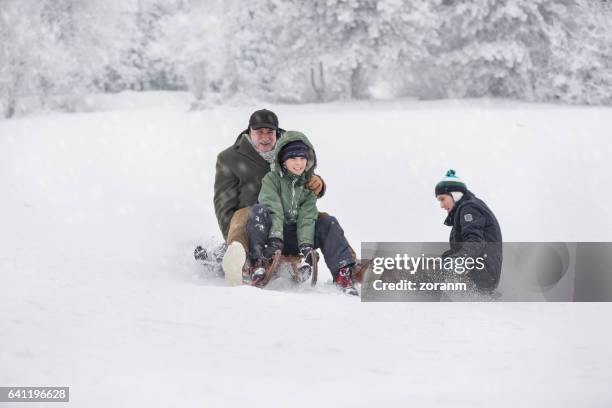 family having fun on snow - grandfather child snow winter stock pictures, royalty-free photos & images