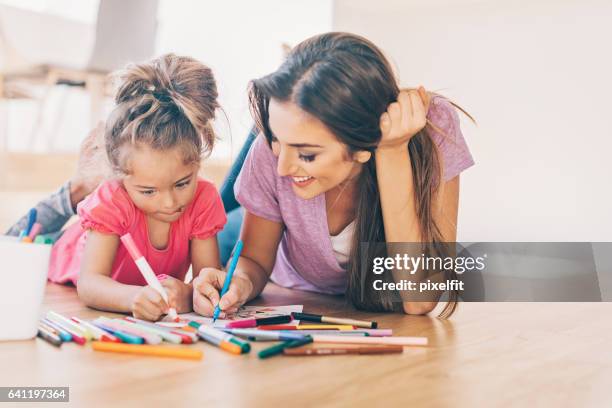 mother and daughter coloring on the floor - coloring in stock pictures, royalty-free photos & images