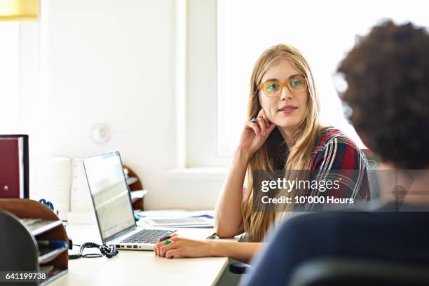 colleagues in a business start-up discussing ideas at their workstations - office woman blond stock pictures, royalty-free photos & images