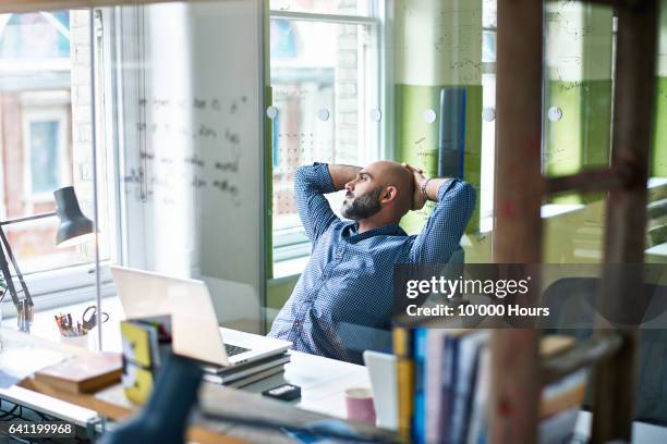 man in office. - hands behind head - fotografias e filmes do acervo