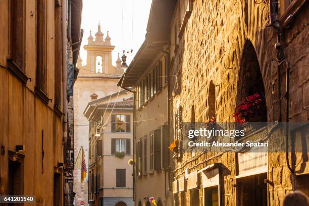 sunny street with bell tower of the old church in citta alta, bergamo, lombardy, italy - bergamo alta stock pictures, royalty-free photos & images