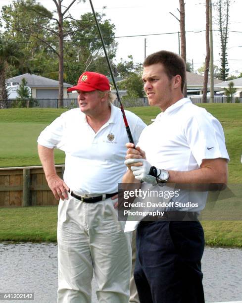 American football player Tom Brady tees off, watched by real estate developer Donald Trump, on the course at Trump International Golf Club, Palm...